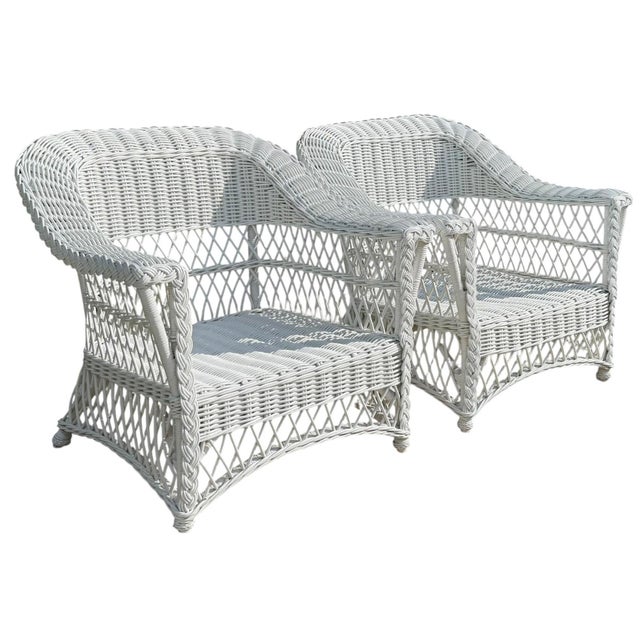 Striking vintage pair of handwoven rattan lounge chairs with beautifully sculptural silhouettes and distinctive braided...