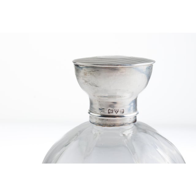 Edwardian perfume bottle in clear blown glass with a spherical form, fitted with a sterling silver collar and domed cap...