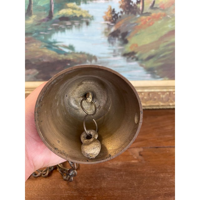 This vintage brass toned hanging bell features intricate hand-painted decoration with traditional Indian motifs. The...