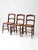 This set of three antique cane dining chairs dates to the late 19th to early 20th century. Warm wood frames pair with...