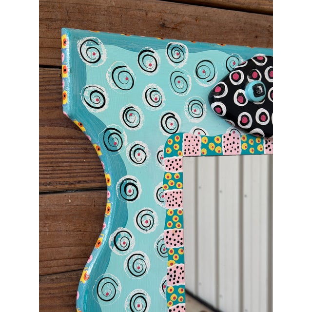 A wonderfully whimsical hand-painted wall mirror by artist Wendy McKinney, signed and dated 1998. The sculptural wood...