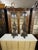 A pair of antique Chinese table lamps in a dark brown soapstone with streaks of lighter, cream-colored veins that are...