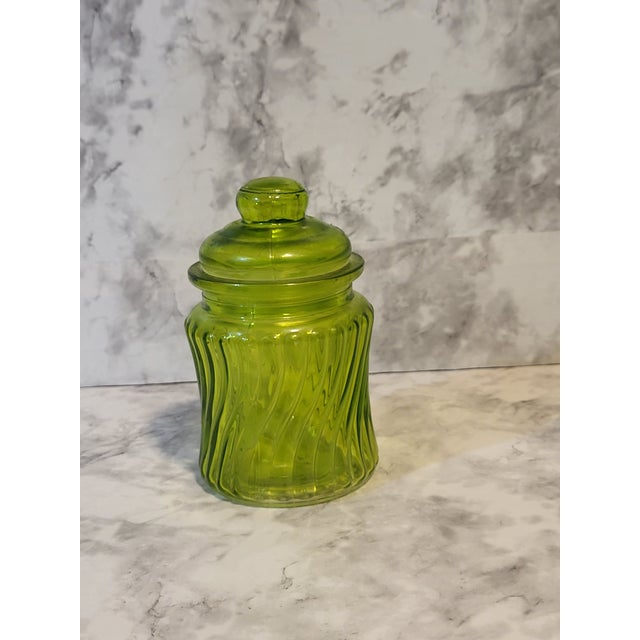Green glass apothecary jar with a glass lid and a plastic gasket. Has a beautiful optic swirl design.