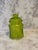 Green glass apothecary jar with a glass lid and a plastic gasket. Has a beautiful optic swirl design.