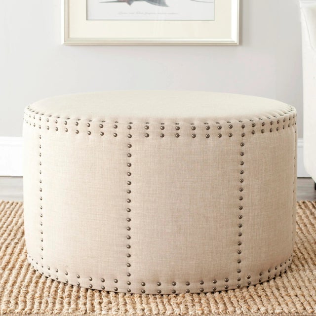Brass nailhead details infuse the round ottoman with a hint of traditional masculine edge. Crisp linen blend fabric in...