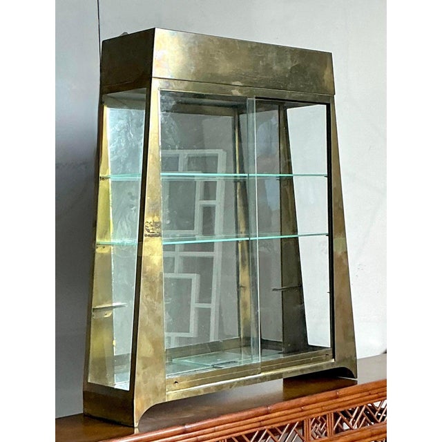Discover the architectural glamour of this monumental vintage brass vitrine. Defined by its bold, trapezoidal silhouette...