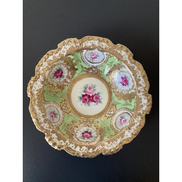 A beautiful bowl with gold embossed detailing, circa early 20th century, Japan. Gilded golden garlands adorn the scalloped...