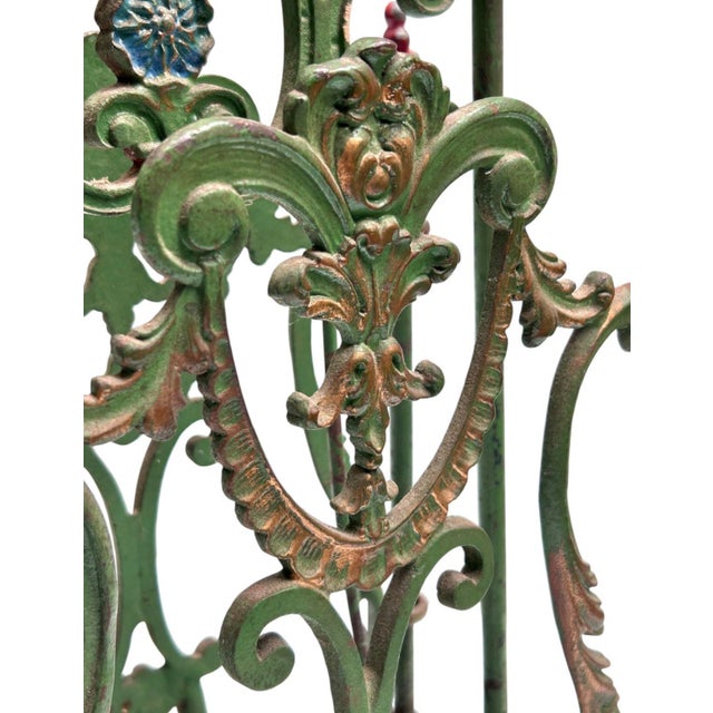 The French early Art Nouveau cast iron magazine rack is painted green with red, blue, and gilded details. Perfectly...