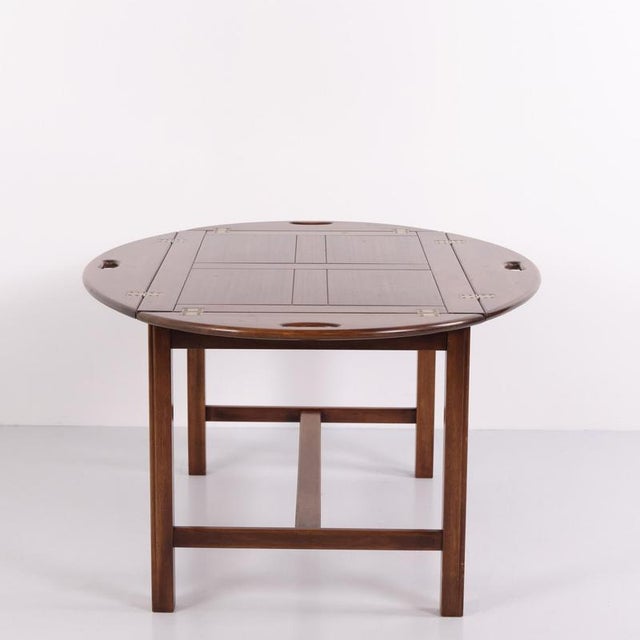 Large Butler coffee table crafted in polished mahogany with brass fittings. Dating from around the 1940s, the table...