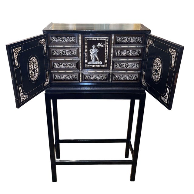 An exquisite 19th century Italian ebonized cabinet masterfully embellished with intricate engraved bone inlay and executed...
