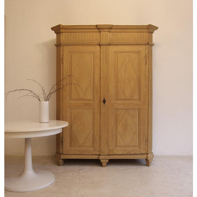 Provincial classicist two-door hall cabinet or wardrobe from around 1800. Solidly crafted in poplar wood with original...