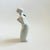 A vintage porcelain creamer or milk pitcher in the shape of a woman. There is a hole on the back for filling and a hole in...