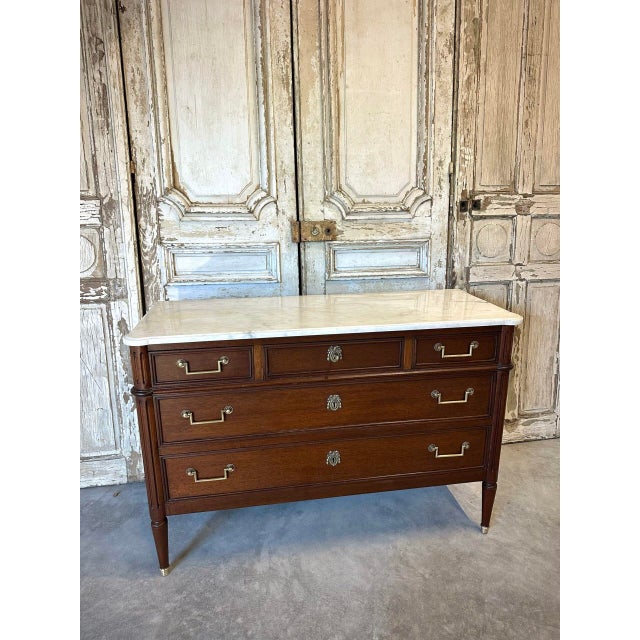 Louis xvi style mahogany and mahogany veneer commode, circa 1950. Fluted uprights terminating in bronze sabots. The front...