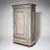 Single-door Louis XVI cabinet with fluted paneling, chamfered corners, and a drawer in the base section. The cornice is...
