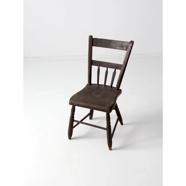 This antique primitive wood chair, dating to the late 1800s, features a simple yet functional design with two back rails,...