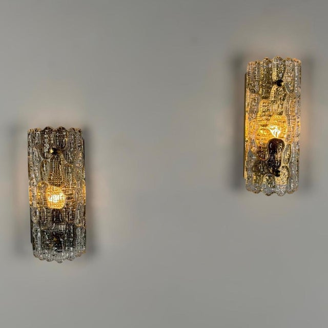 A striking pair of sculptural wall lights designed by carl fagerlund for orrefors in the 1970s, featuring richly textured...