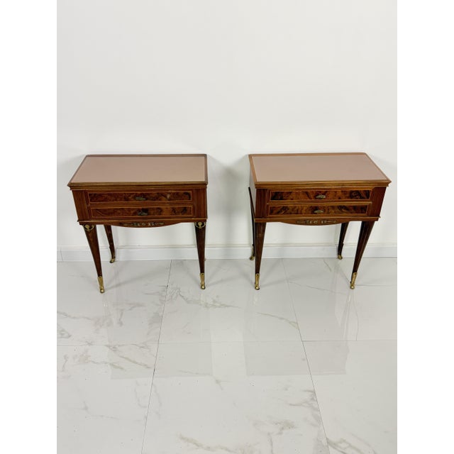 Set of two elegant Italian bedside tables with pink glass top and brass feet, 1950s Bronze fittings, two drawers on the...