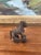 Small likely antique bronze toned figurine depicting a stylized horse mounted on four functional wheels.Likely originating...