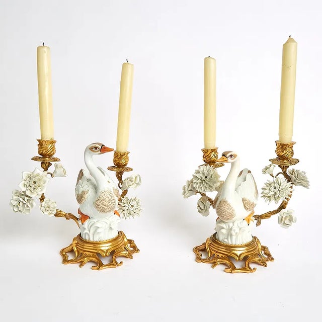 Whimsical pair of porcelain and gilt metal candelabra with swan-shaped figures at the center. These white and gold pieces...