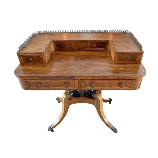 Six drawer rosewood Carlton Desk Inlaid detailing throughout Brass gallery Pedestal base Brass cuffed paw feet on castors...