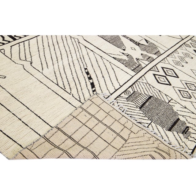 Beautiful modern Moroccan style hand-knotted wool rug with a beige field. This piece has gray accent color in a gorgeous...