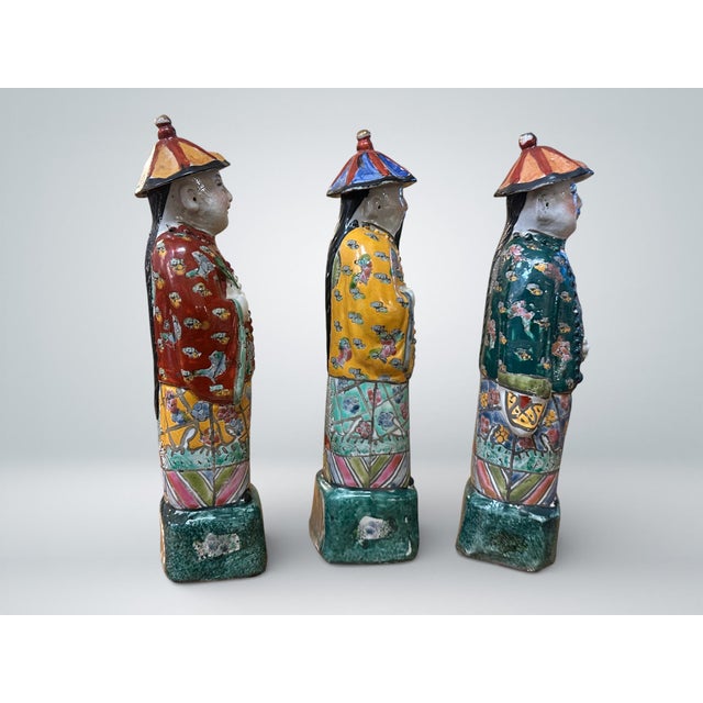 Set of 3 Chinese polychrome glazed porcelain figures. All three are stamped to the underside. The estimated date of...