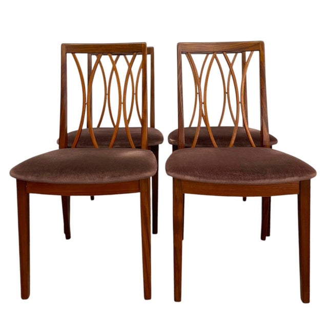 Set of four mid century modern dining chairs, imported from the United Kingdom, featuring a distinctive sculptural a...