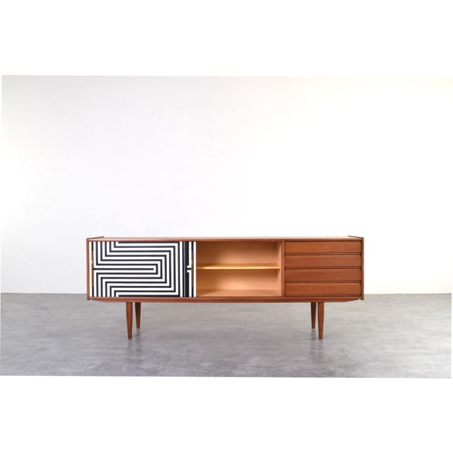 This Danish sideboard from the 1960s is a classic example of mid-century modern design, where simplicity of form is...