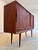 This Danish highboard from the mid-century era is a true masterpiece of Scandinavian storage solutions, captivating with...