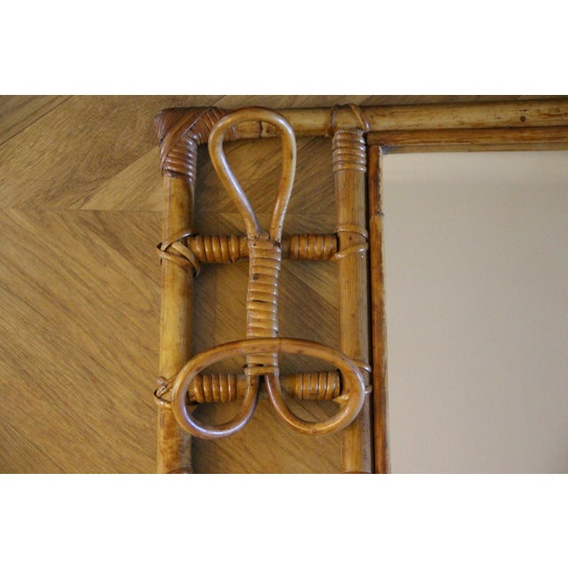 This highly decorative mirror and coat rack, made of rattan and bamboo, was crafted in Italy in the 1960s. It is typical...