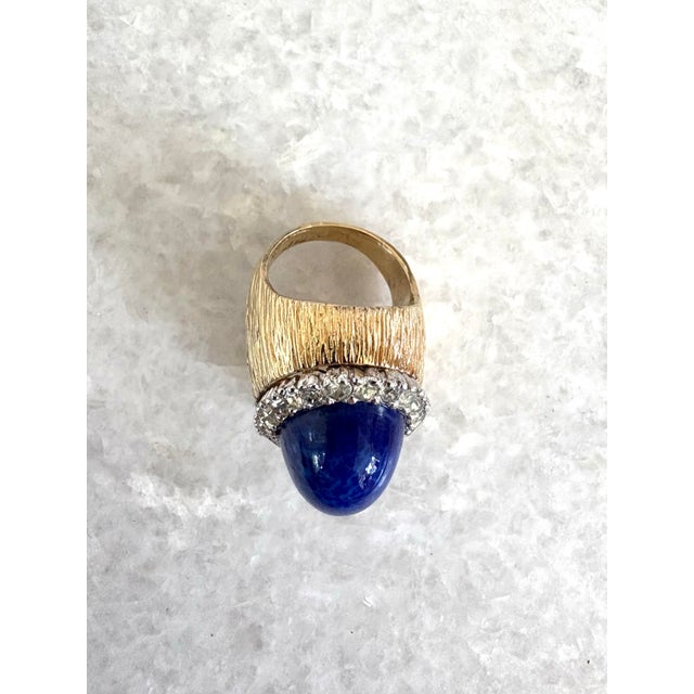 A wonderfully dramatic and vibrant cocktail ring featuring a blue lapis, surrounded by sparkling rhinestones set in a...