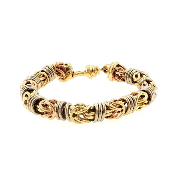 A Byzantine-style bracelet crafted in 18k gold. This piece features intricate interlocking links, showcasing a tri-color...