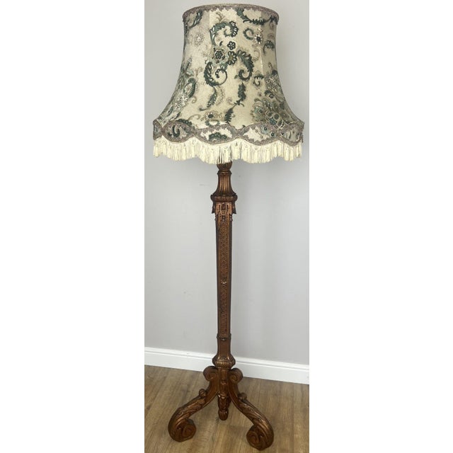 A beautifully decorative Vintage French standing lamp featuring an elegant carved base and a richly patterned fabric shade...