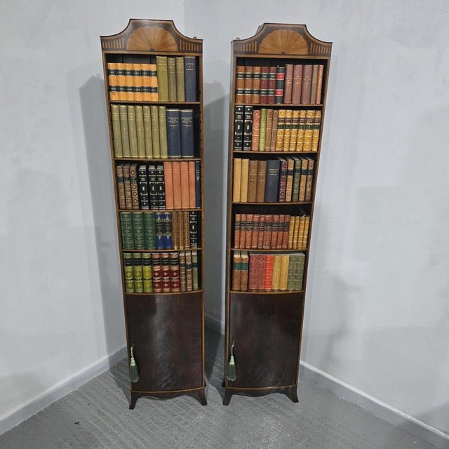 A superior quality pair of Edwardian mahogany bow fronted open adjustable library bookcases of slim propportions,...