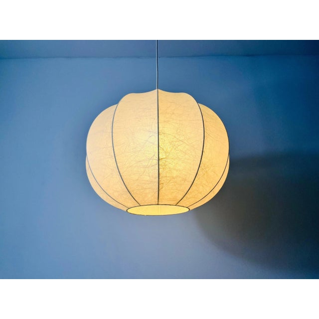 A cocoon hanging lamp made in Italy in the 1960s. It has a beautiful round design, which is similar to the lamps made by...