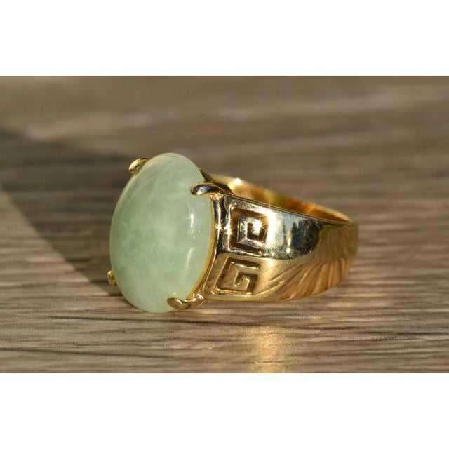 The Elata Ladies Contemporary Jade Cocktail Ring in 14K. This ring centers on an oval cabochon jade prong set in 14 karat...