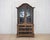 An elegant period Rococo cabinet dating to circa 1820 and featuring beautifully curved lines, glass doors, and refined...