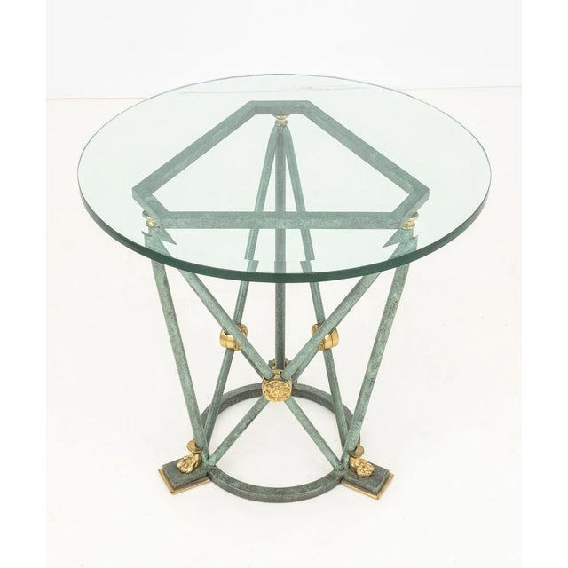 Empire Style Verdigris Patinated and Gilt Metal Occasional Table, with beveled glass top above tripod base with lion's paw...