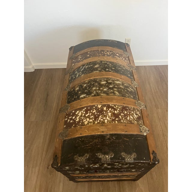 This is an antique camelback or dome-top steamer trunk, likely dating from the late 19th or early 20th century. These...