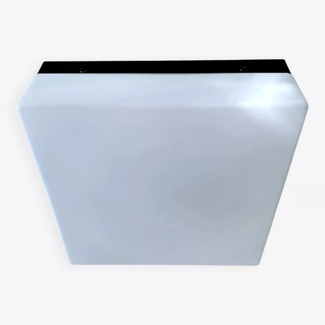 Large vintage flush mount light featuring a opaline glass shade mounted on a black bakelite base, the glass has a slight...