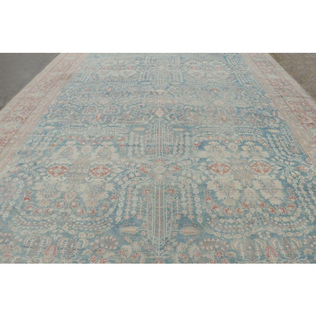 Hand-knotted in wool, this 12x17 antique oversized Persian Sarouk rug enjoys an elegant all-over geometric and floral...