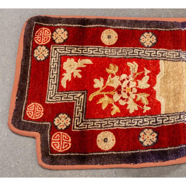 Chinese Wool Saddle Rug, in red and beige with geometric border. 3' 9" L x 1' 10.5" W. Provenance: From an East 86th...
