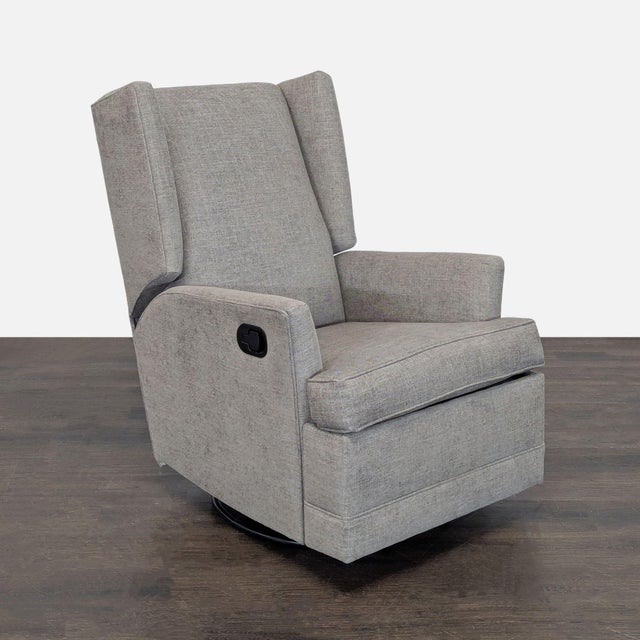 This Pottery Barn lounge chair features a stylish wingback design in a neutral gray fabric. It functions as a comfortable...