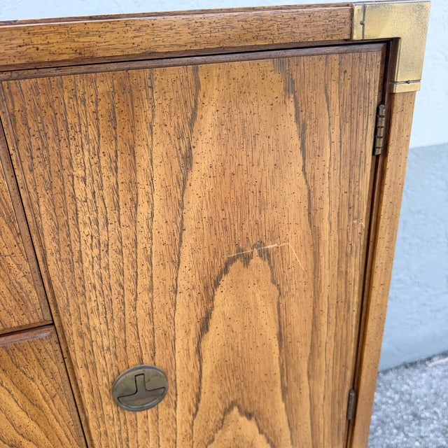 A striking example of Thomasville’s celebrated Huntley Collection, this vintage Campaign highboy dresser blends clean Mid-...