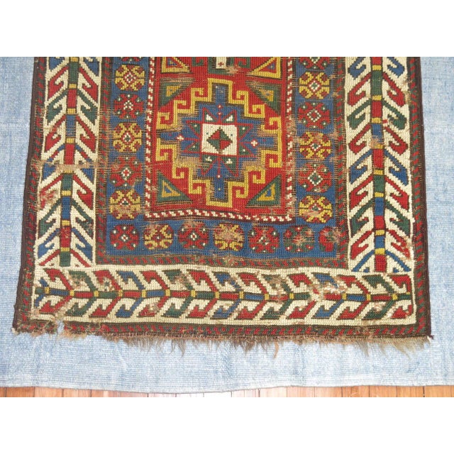 A late 19th century Caucasian Kazak rug stitched onto a light blue Turkish Kilim.