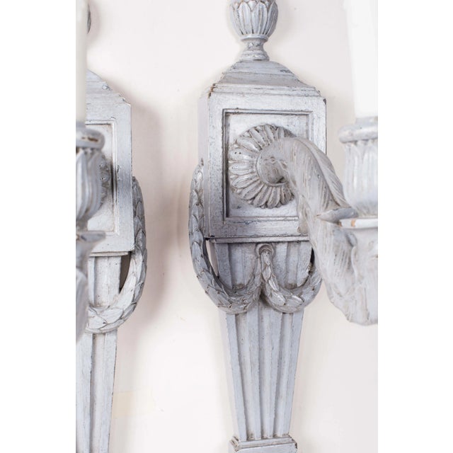 Pair of Empire style painted wood sconces Each with fluted backplate and carved with a garland. Newly wired electrical....