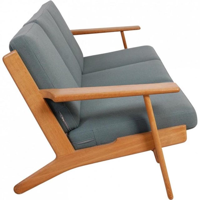 Hans Wegner GE-290 3-seater sofa with a solid oak frame and cushions upholstered in green fabric. The sofa is from the...