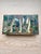 A charming vintage Mexican brass trinket box featuring an intricate semiprecious stone mosaic lid depicting three elegant...