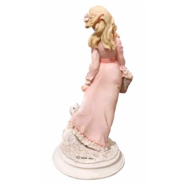 Delightfully charming and finely detailed, this vintage style porcelain figurine captures a sweet pastoral moment of a...