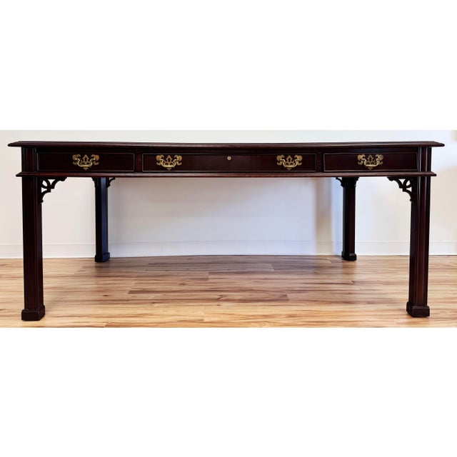 Vintage Sligh Chippendale style mahogany writing desk with tooled red leather rectangular top. Leather top is outlined in...